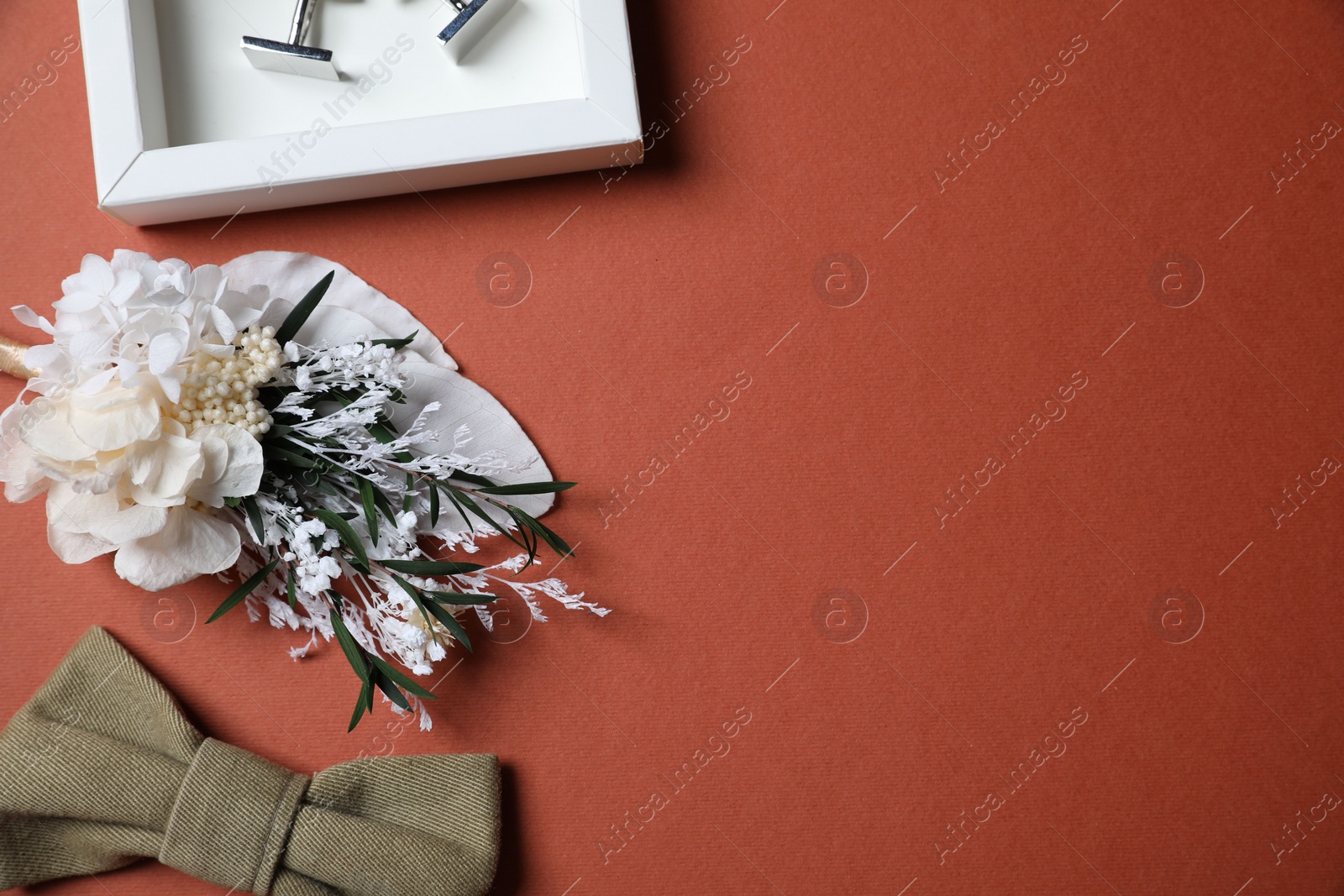 Photo of Wedding stuff. Stylish boutonniere, bow tie and cufflinks on brown background, space for text