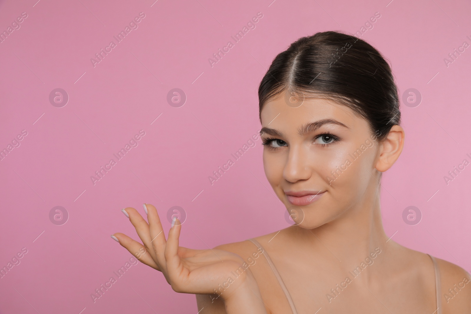 Photo of Portrait of pretty girl on pink background, space for text. Beautiful face with perfect smooth skin