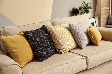 Pillows on modern sofa indoors. Stylish room interior decor