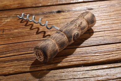 Photo of One corkscrew on wooden table, closeup view