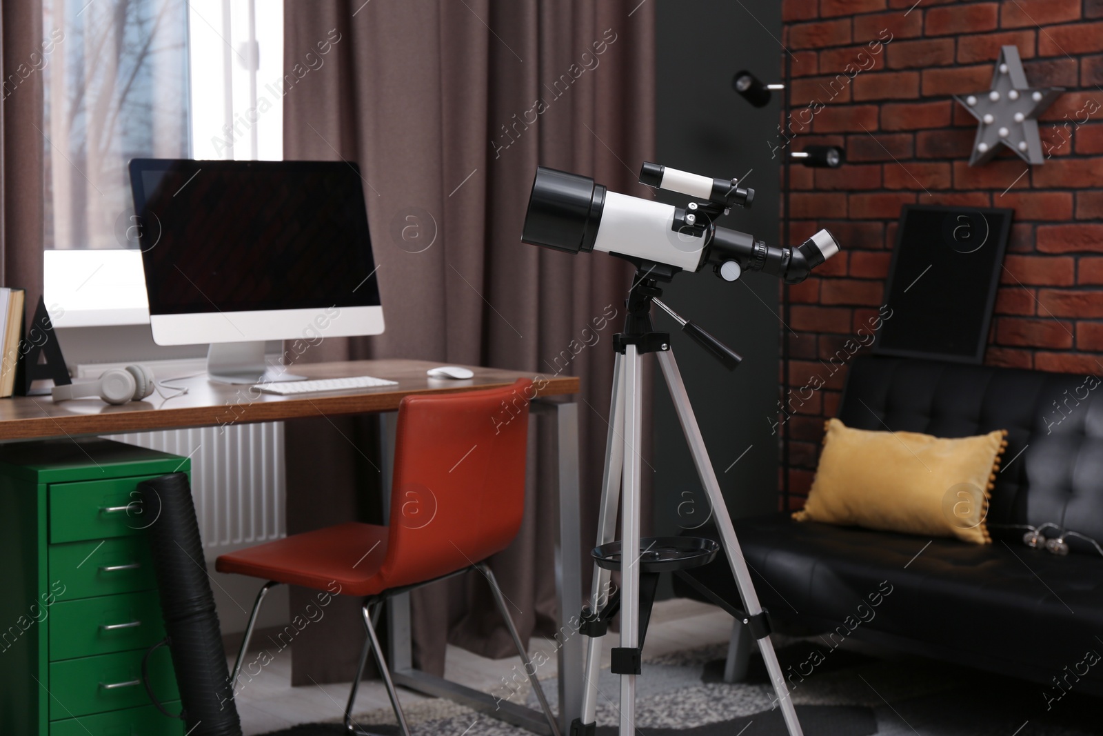 Photo of Tripod with modern telescope in stylish room