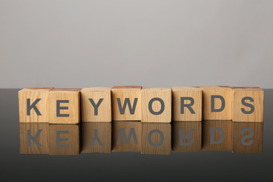 Photo of Wooden cubes with word KEYWORDS on light grey background
