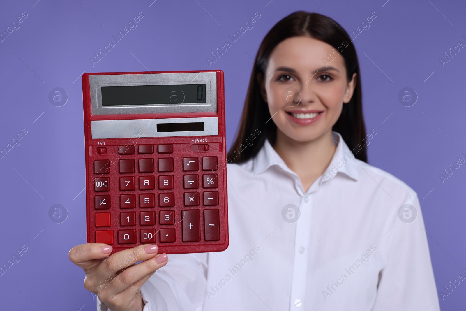 Photo of Smiling accountant against purple background, focus on calculator