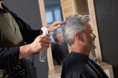 Photo of Hair styling. Professional hairdresser working with client in barbershop, closeup