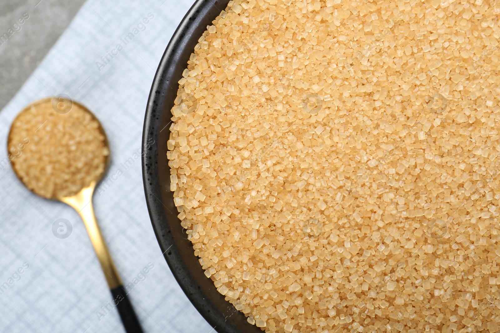 Photo of Brown sugar in bowl and spoon on table, top view