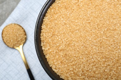 Brown sugar in bowl and spoon on table, top view