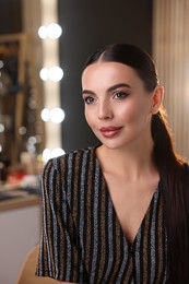 Photo of Beautiful woman wearing makeup in dressing room