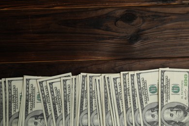 Photo of Money exchange. Dollar banknotes on wooden background, top view. Space for text