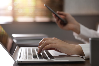 Woman working with laptop in office, closeup