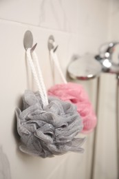 Shower puffs hanging near faucet in bathroom