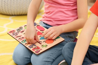 Photo of Children playing with math game kit on floor, closeup. Learning mathematics with fun
