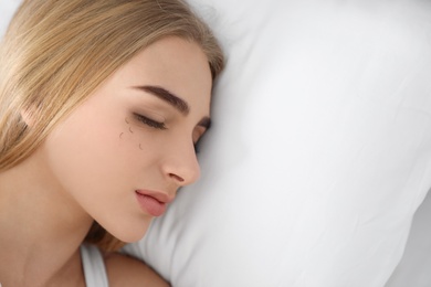 Photo of Young woman with eyelash loss problem sleeping in bed