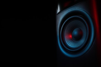 Photo of One sound speaker in neon light on black background, closeup. Space for text