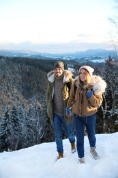 Happy couple spending winter vacation together in mountains