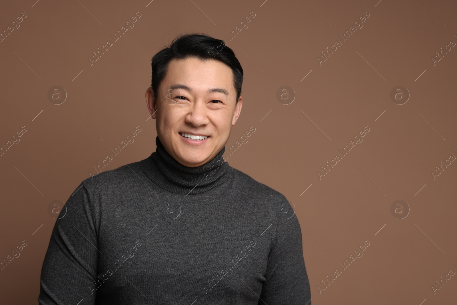 Photo of Portrait of happy man on brown background. Space for text