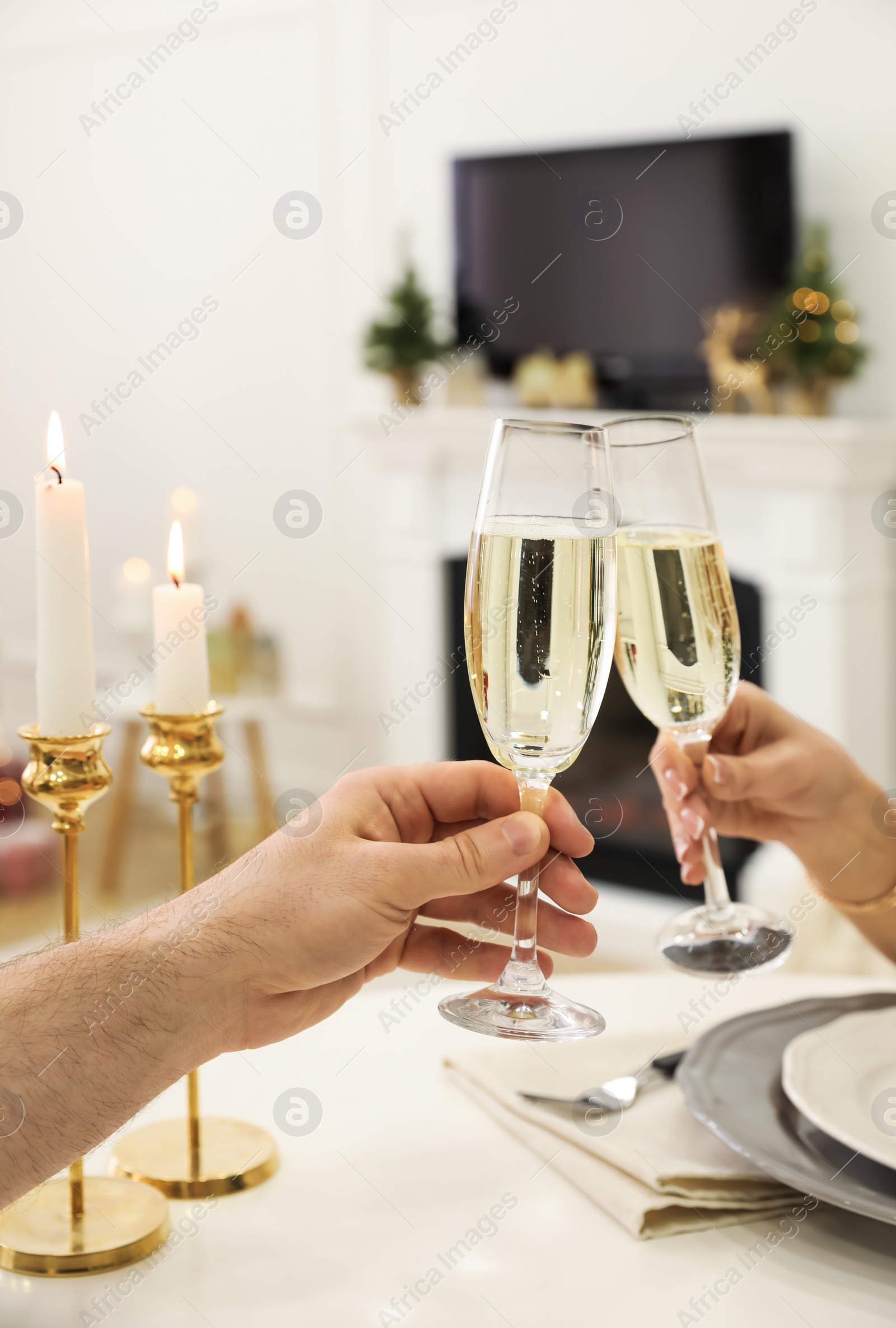 Photo of People clinking glasses with champagne at home, closeup