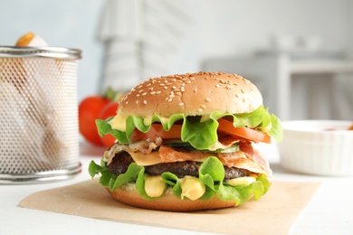 Photo of Tasty burger with bacon served on table