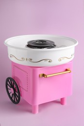 Photo of Portable candy cotton machine on violet background