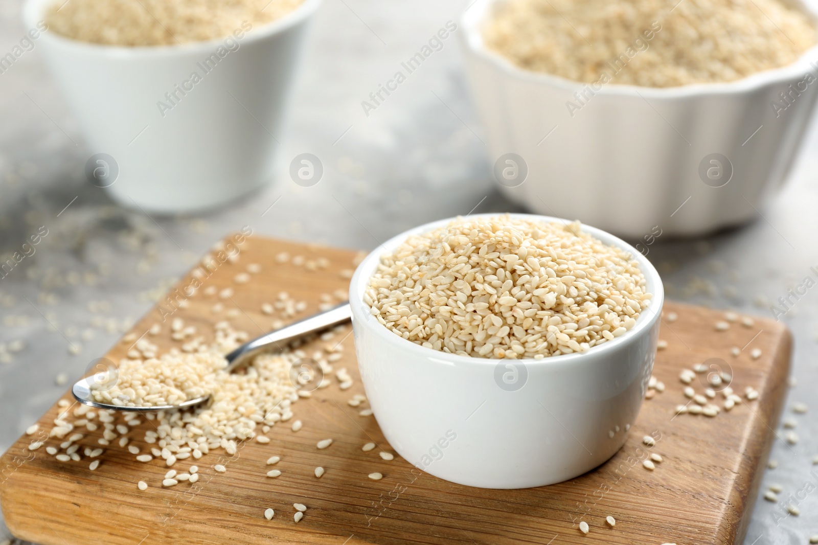 Photo of White sesame seeds on light grey table