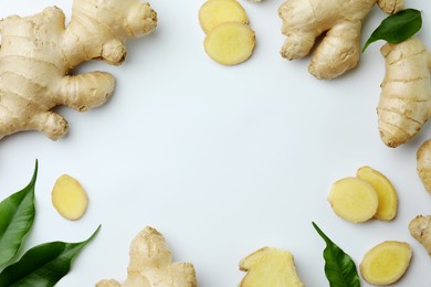 Photo of Frame of fresh ginger with green leaves on white background, flat lay. Space for text