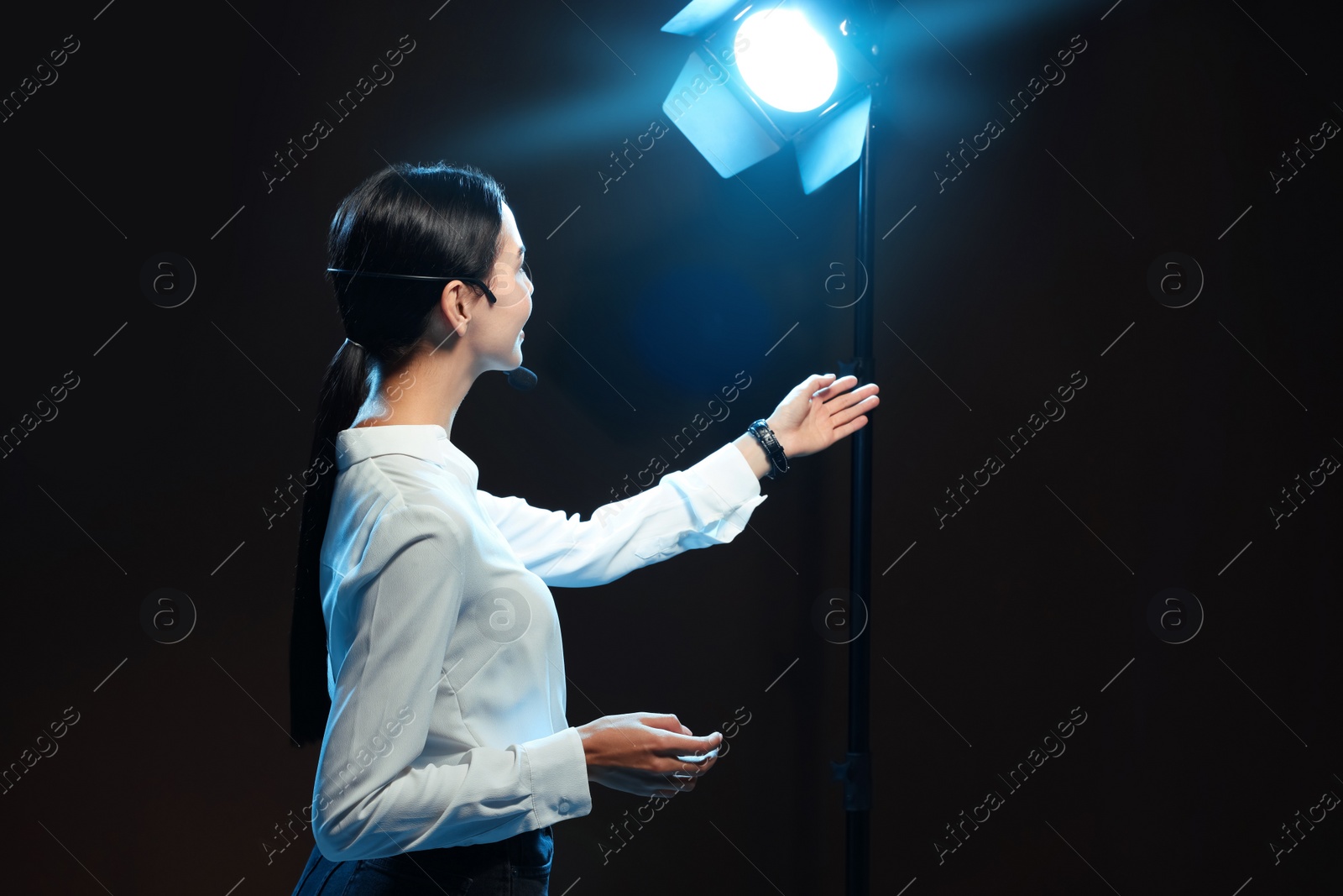 Photo of Motivational speaker with headset performing on stage. Space for text