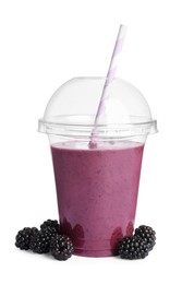 Plastic cup of tasty blackberry smoothie and fresh fruits on white background