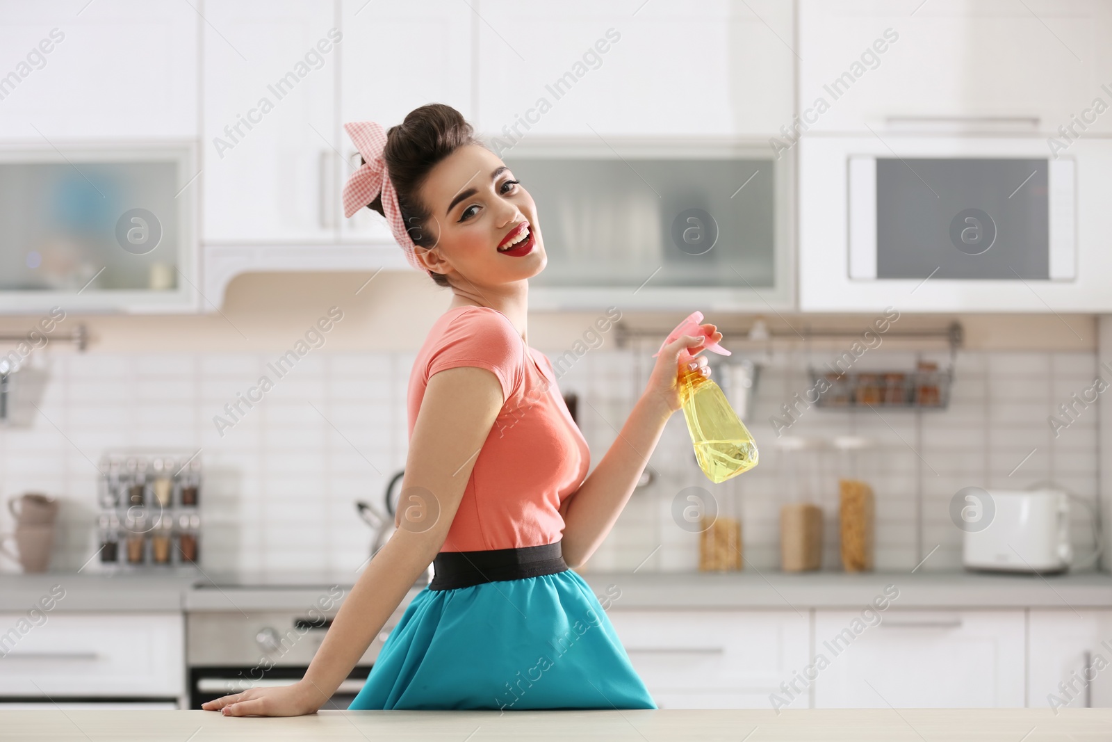 Photo of Funny young housewife with detergent in kitchen