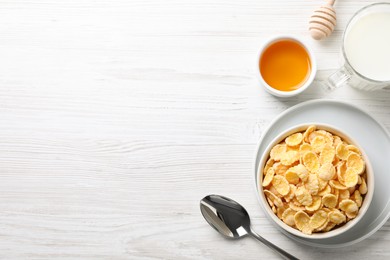Photo of Tasty crispy corn flakes served with milk and honey on white wooden table, flat lay. Space for text