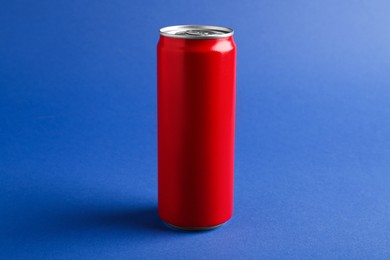 Photo of Energy drink in red can on blue background