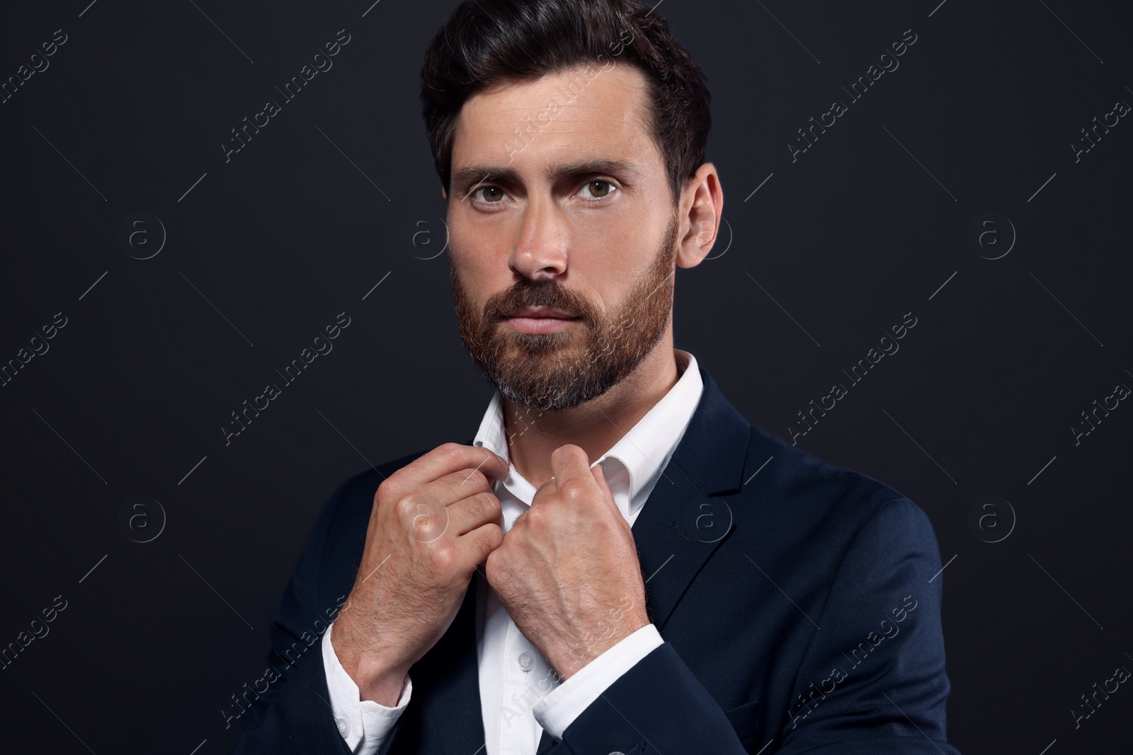 Photo of Portrait of handsome bearded man on black background