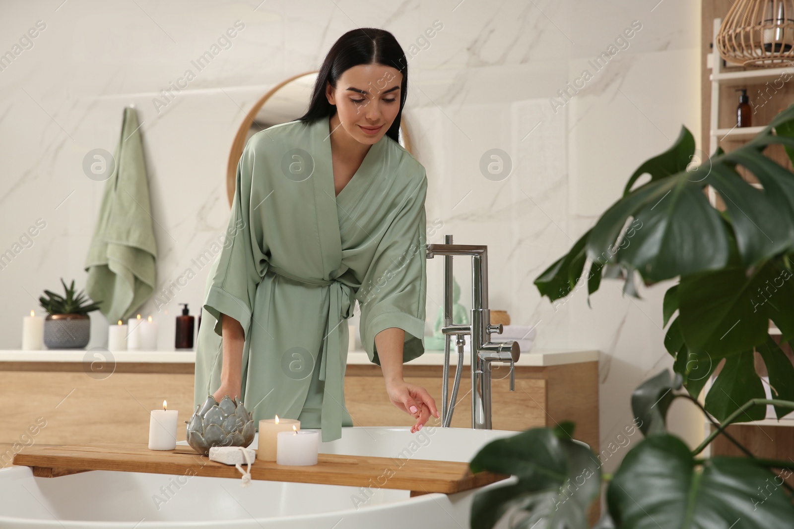 Photo of Beautiful young woman near tub in bathroom