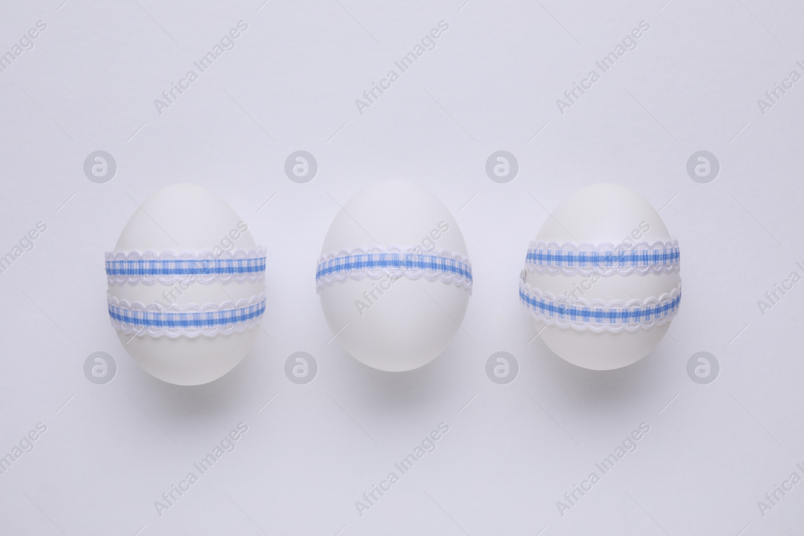 Photo of Festively decorated Easter eggs on white background, top view