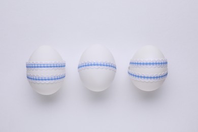 Festively decorated Easter eggs on white background, top view