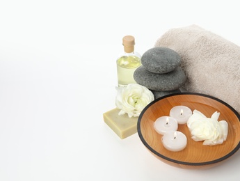 Beautiful spa composition with candles and stones on white background