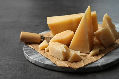 Photo of Marble board with delicious cheese on table, closeup