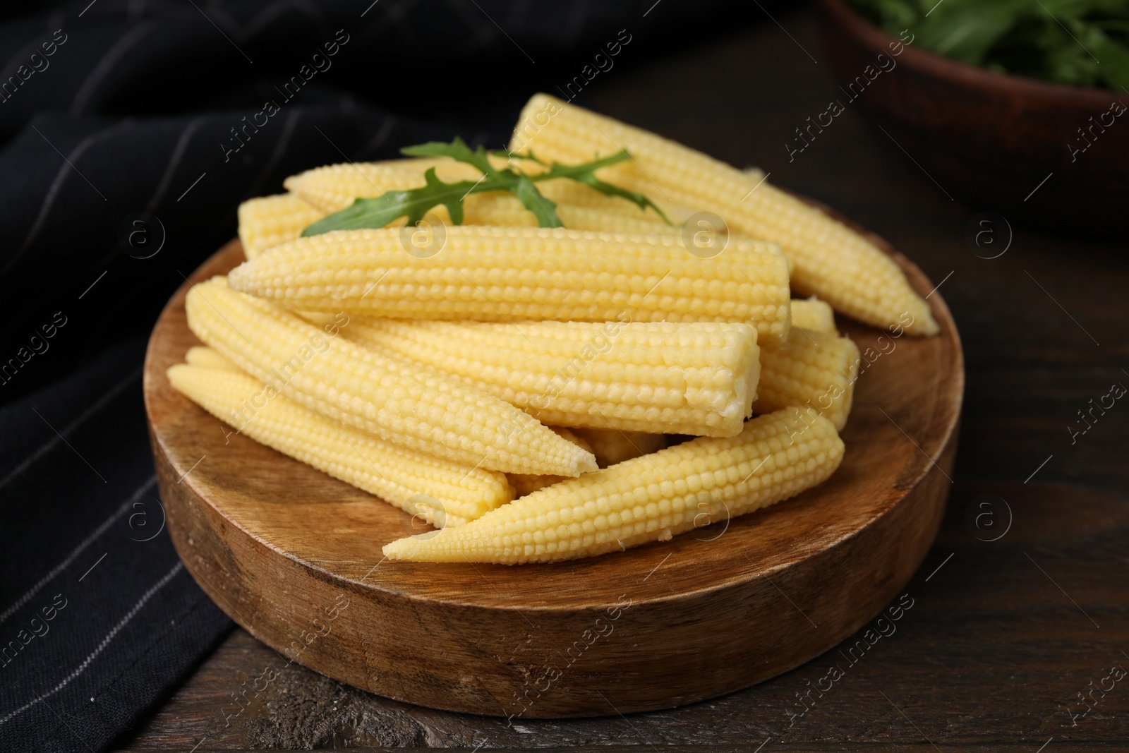 Photo of Tasty fresh yellow baby corns on wooden table