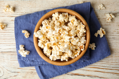 Tasty pop corn on white wooden table, flat lay