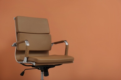 Photo of Modern office chair on orange coral background. Space for text