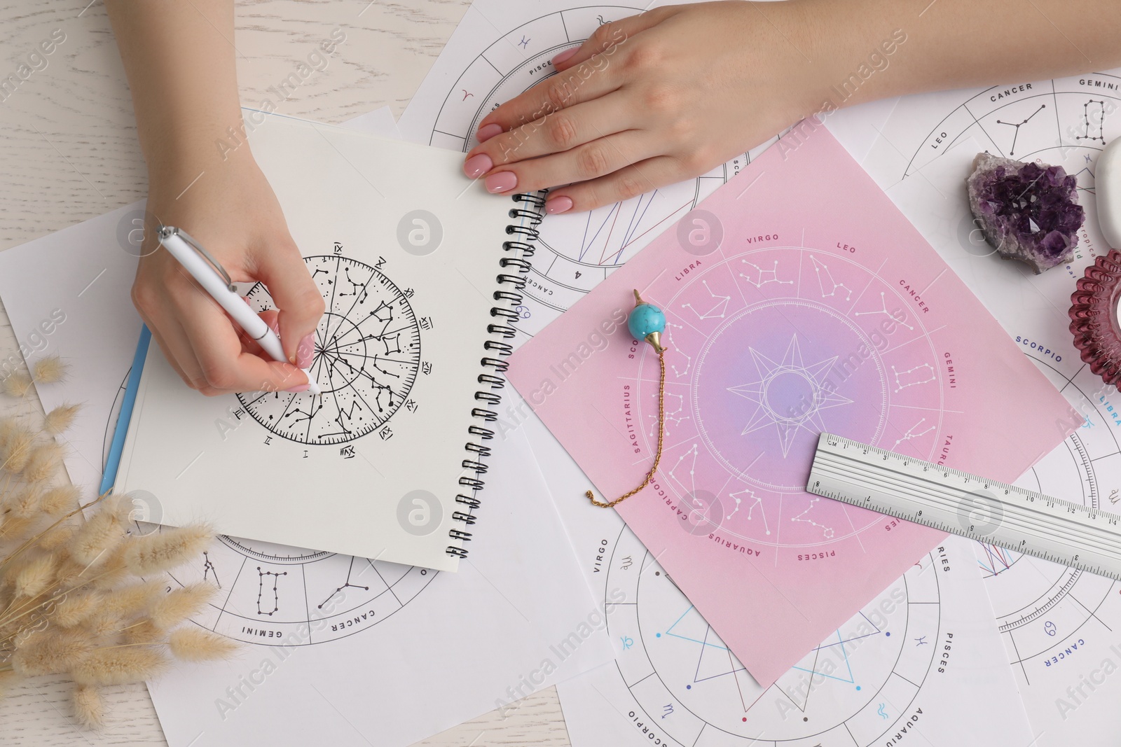 Photo of Astrologer using zodiac wheel for fate forecast at table, top view. Fortune telling