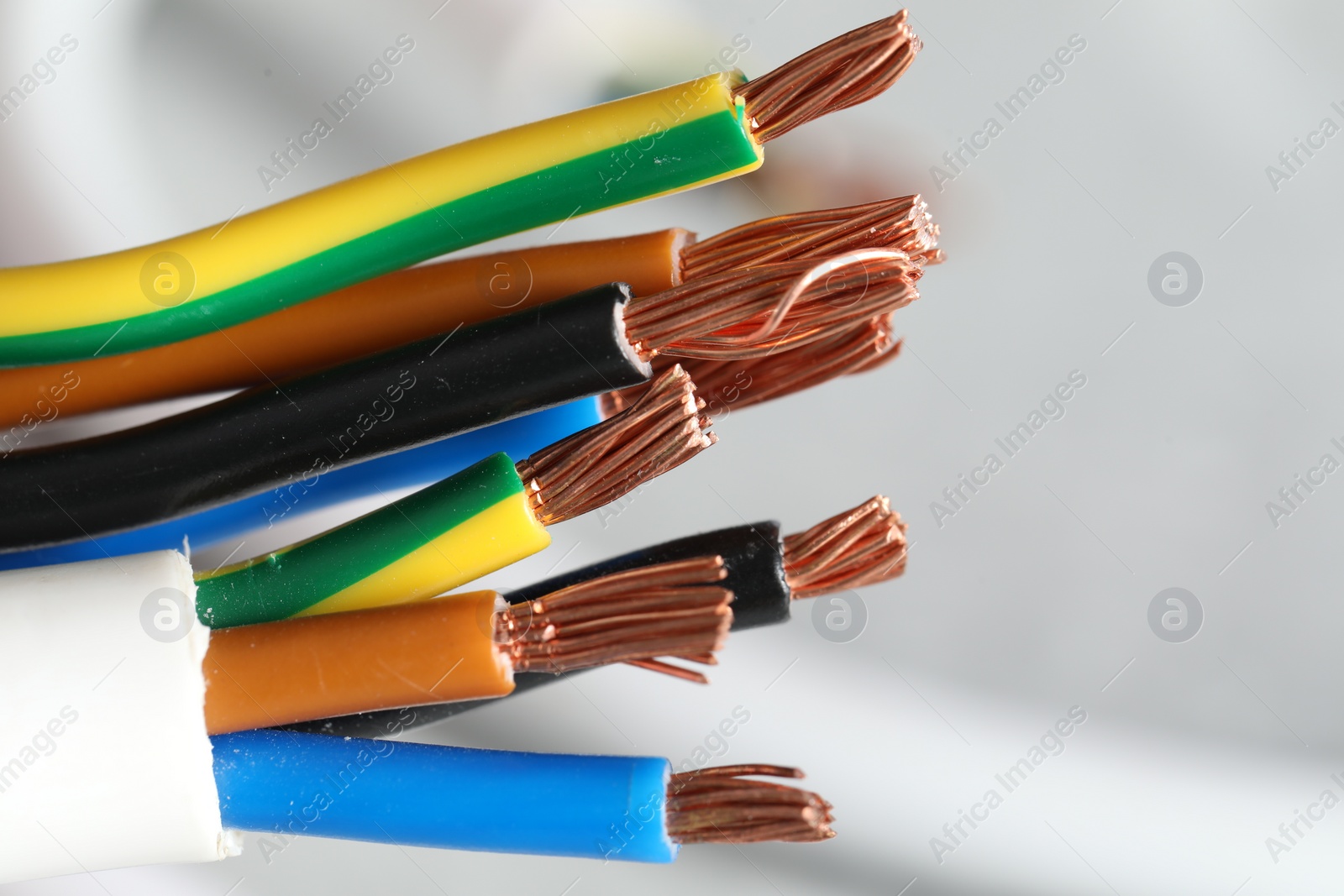 Photo of Colorful electrical wires on light background, closeup. Space for text