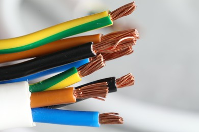 Photo of Colorful electrical wires on light background, closeup. Space for text