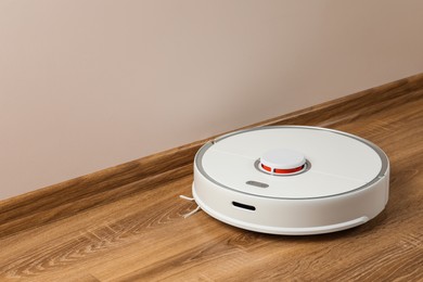 Photo of Robotic vacuum cleaner on wooden floor indoors