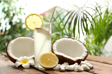 Composition with glass of coconut water and lemon on wooden table