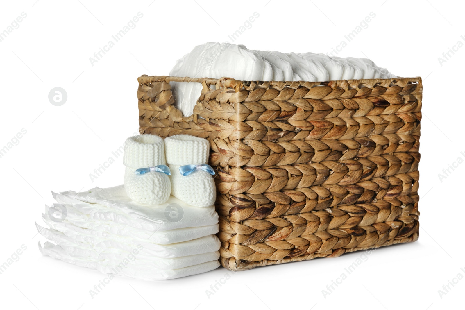 Photo of Disposable diapers and child's booties on white background