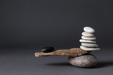 Photo of Stones with tree branch on black background. Harmony and balance concept