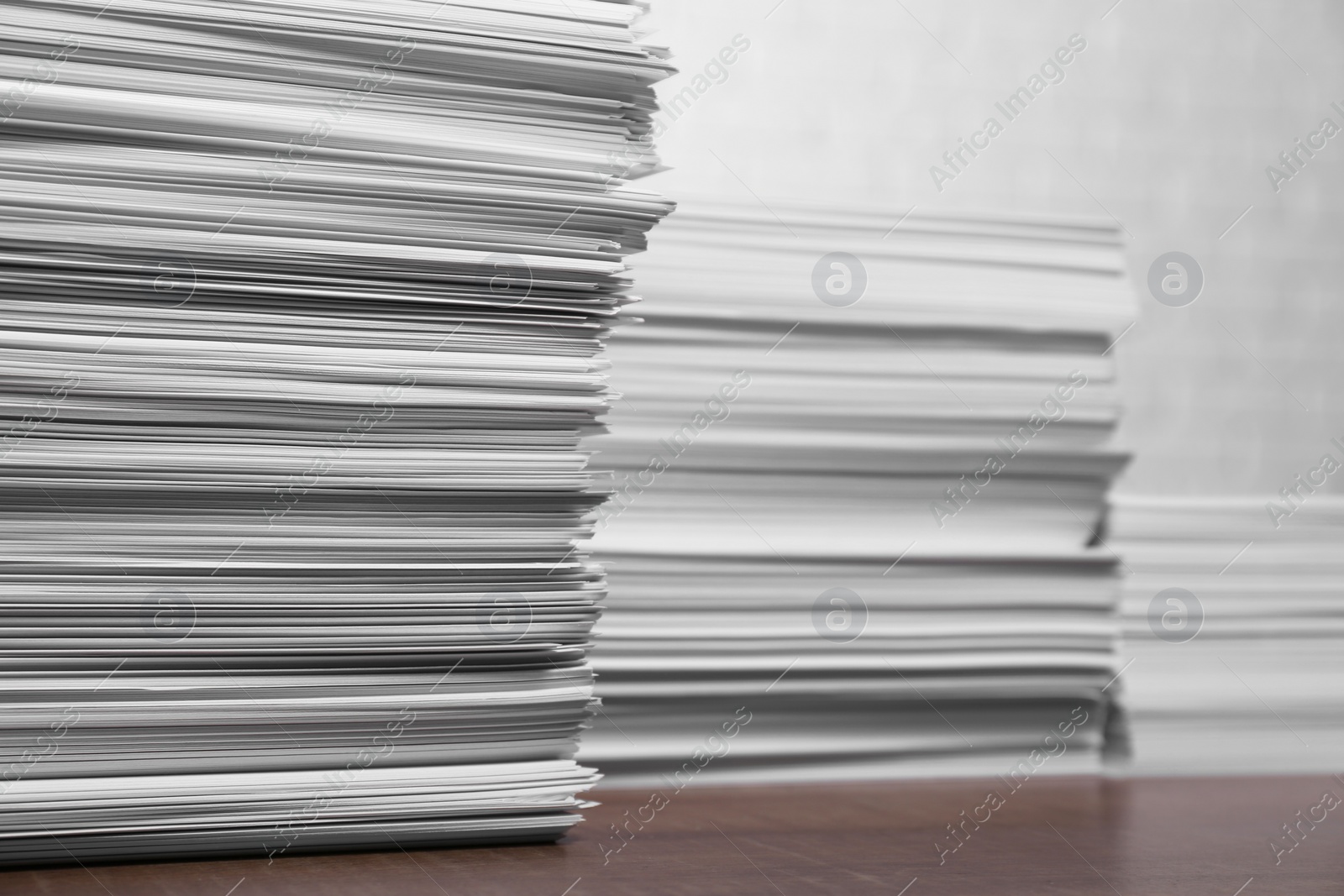 Photo of Stacks of white paper sheets on wooden table, space for text