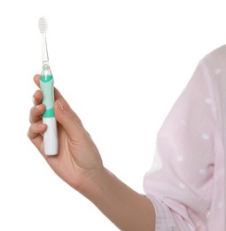 Photo of Woman holding electric toothbrush on white background, closeup