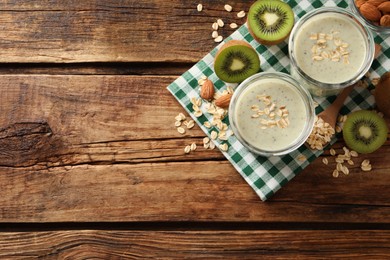 Photo of Flat lay composition with tasty kiwi oatmeal smoothie on wooden table. Space for text