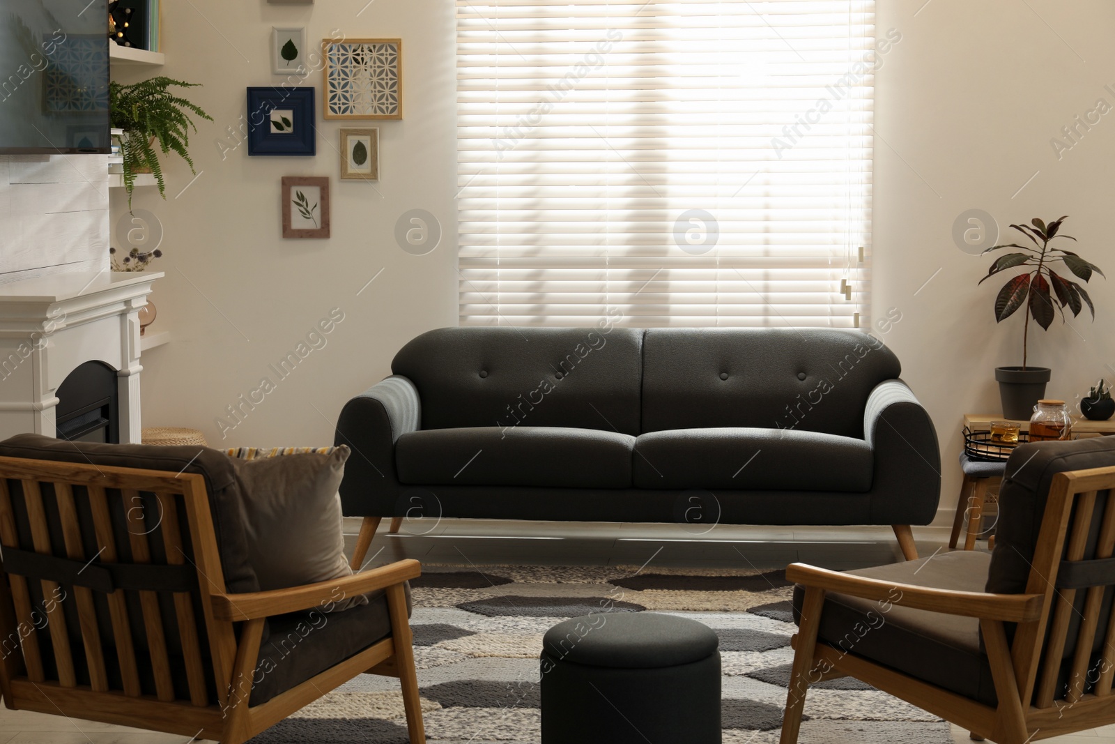 Photo of Cozy living room interior with comfortable sofa, armchairs and decorative fireplace