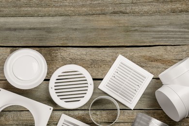 Parts of home ventilation system on wooden surface, flat lay. Space for text